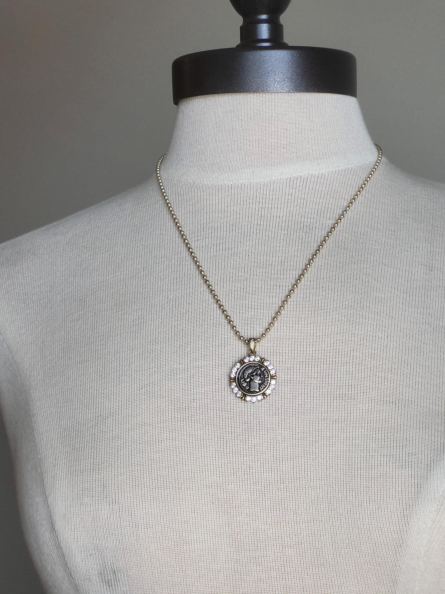 small mixed metal Greek coin pendant on gold ball chain.