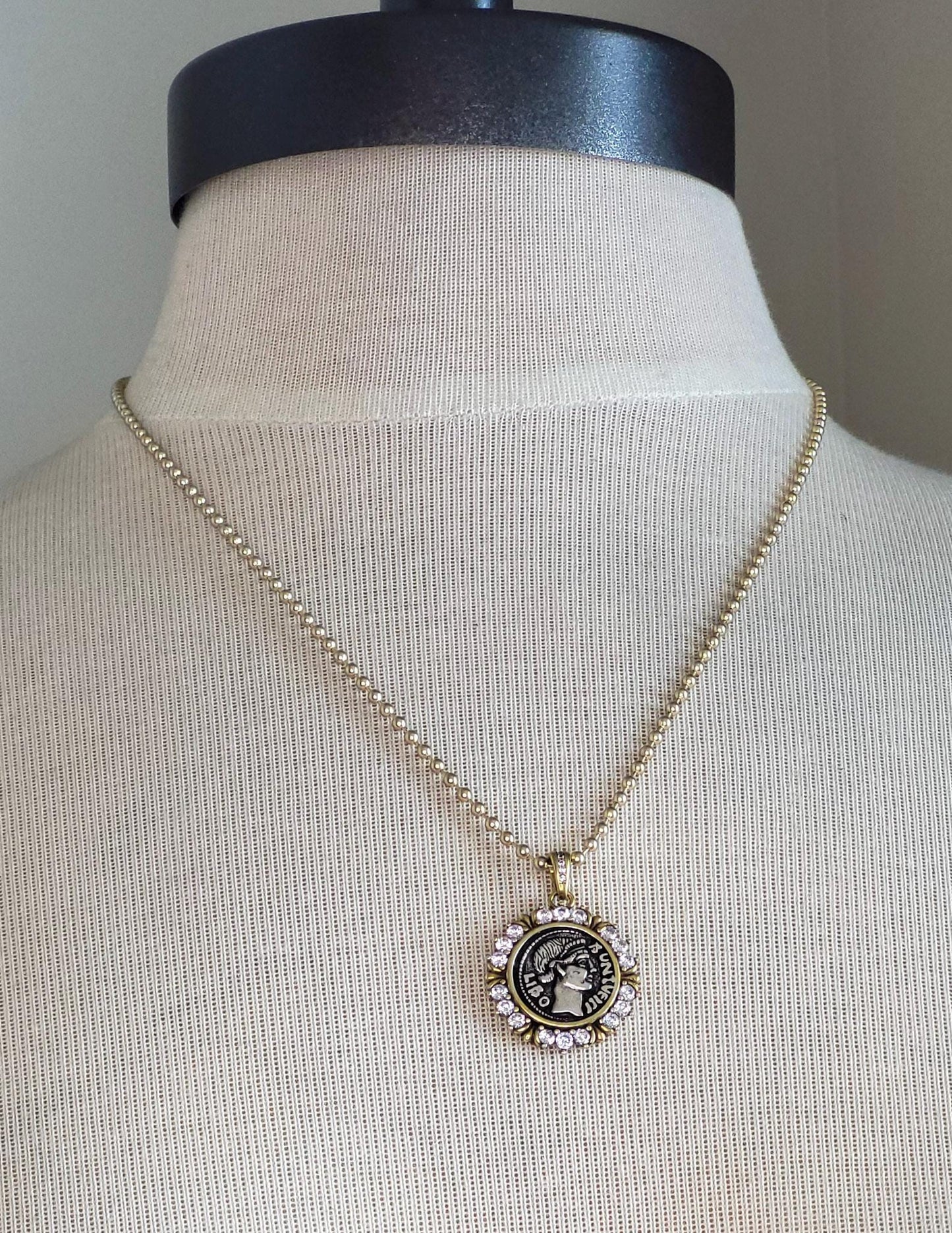 small mixed metal Greek coin pendant on gold ball chain.